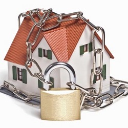 A toy house with a lock and chains around it to depict safety and security
