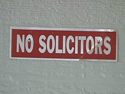 A sign for no Solicitors on wall