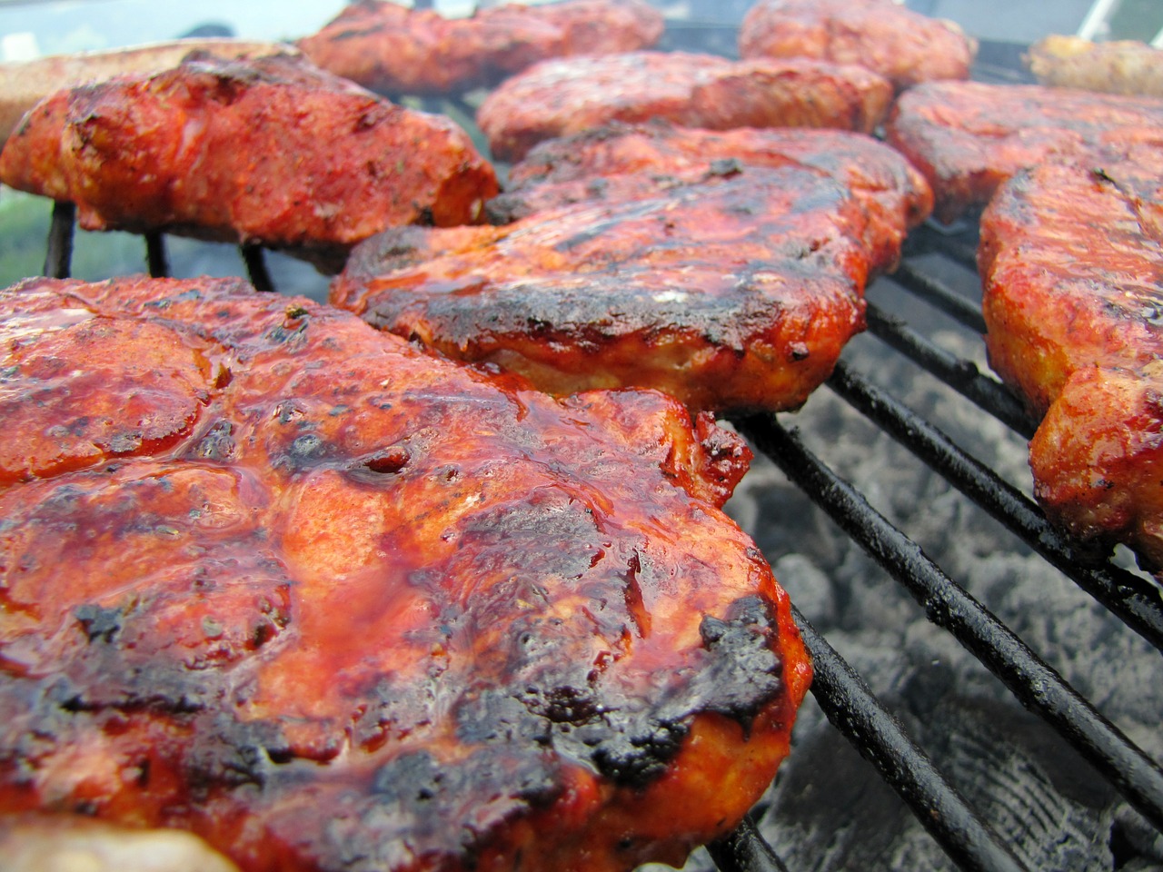Image of meat grilling on grill to depict safe grilling outdoors